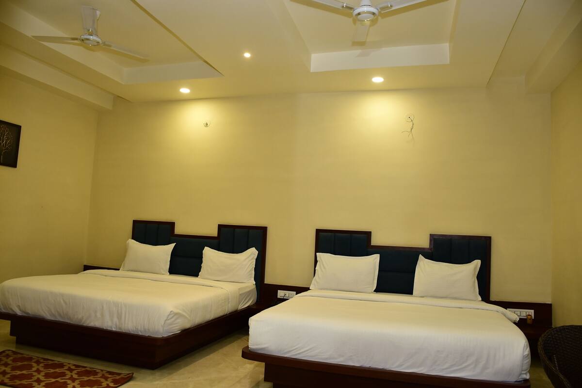 A hotel room with two beds, a ceiling fan, recessed lighting, and a small rug.