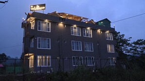 Un edificio de varios pisos con ventanas iluminadas y un letrero.
