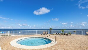 A swimming pool with a view of the sea, surrounded by lounge chairs and a white fence. - What A View! Marina, Intracoastal, Gulf Islands National Seashore & The Gulf (Pensacola)