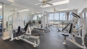 A gym with various exercise machines, large windows, and ceiling fans. - What A View! Marina, Intracoastal, Gulf Islands National Seashore & The Gulf (Pensacola)