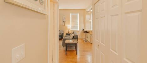 A hallway leading to a living room with a sofa, a coffee table, and a lamp.