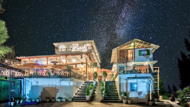A hotel with a balcony, a staircase, and potted plants. - Ekaanth by Paradise Chateau (Manali)