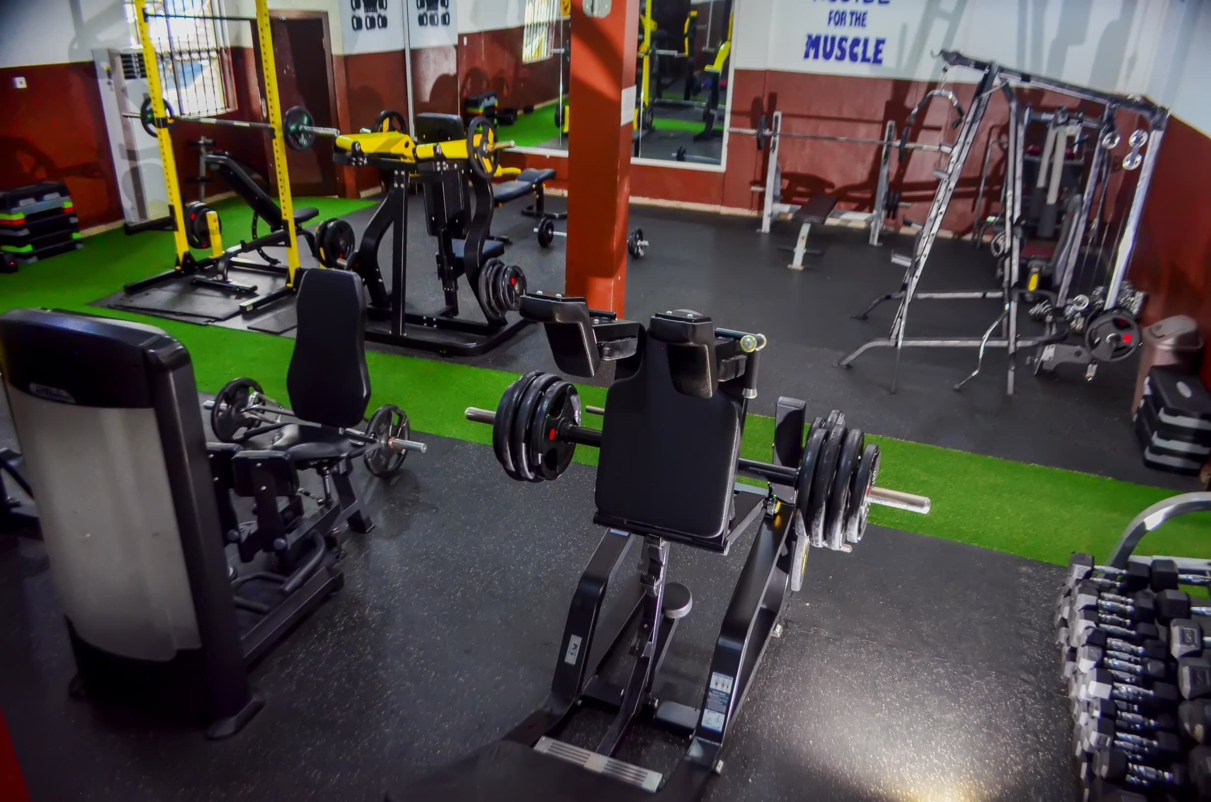 A gym with various exercise equipment, including weight machines and free weights.