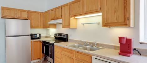 A modern kitchen with wooden cabinets, stainless steel appliances, and a dishwasher.