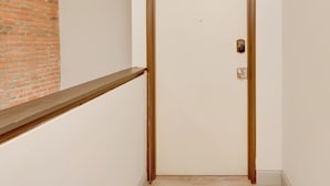 Une porte fermée, dotée d’un cadre en bois et d’un petit judas.