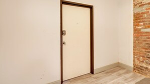 Une porte fermée, avec un cadre en bois, une petite poignée en métal et un interrupteur sur le mur.