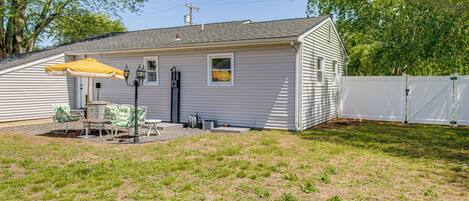 A single-story house with a covered patio area, a fenced yard, and a white fence.