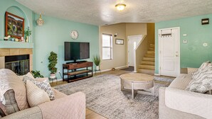 A living room with a fireplace, television, and a staircase leading to another level. - Balloon Fiesta Base in Abq's Ventana Ranch (Albuquerque)