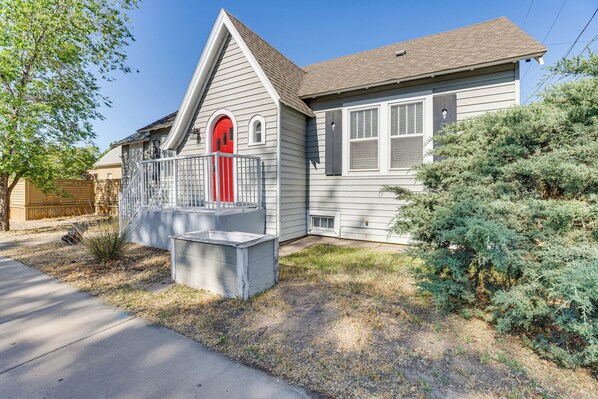 A single-story house with a red front door, a small porch, and a covered front yard. - Walk to Main St - Grand Junction Home w/ Gazebo! (Grand Junction)