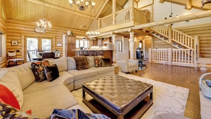 A spacious log cabin interior with a large living area, a dining area, and a staircase leading to an upper level. - 'nonna's Cabin' Family Mtn Retreat in Westcliffe! (Westcliffe)