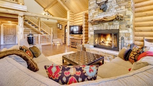 A log cabin interior with a stone fireplace, a television, and a cozy seating area. - 'nonna's Cabin' Family Mtn Retreat in Westcliffe! (Westcliffe)