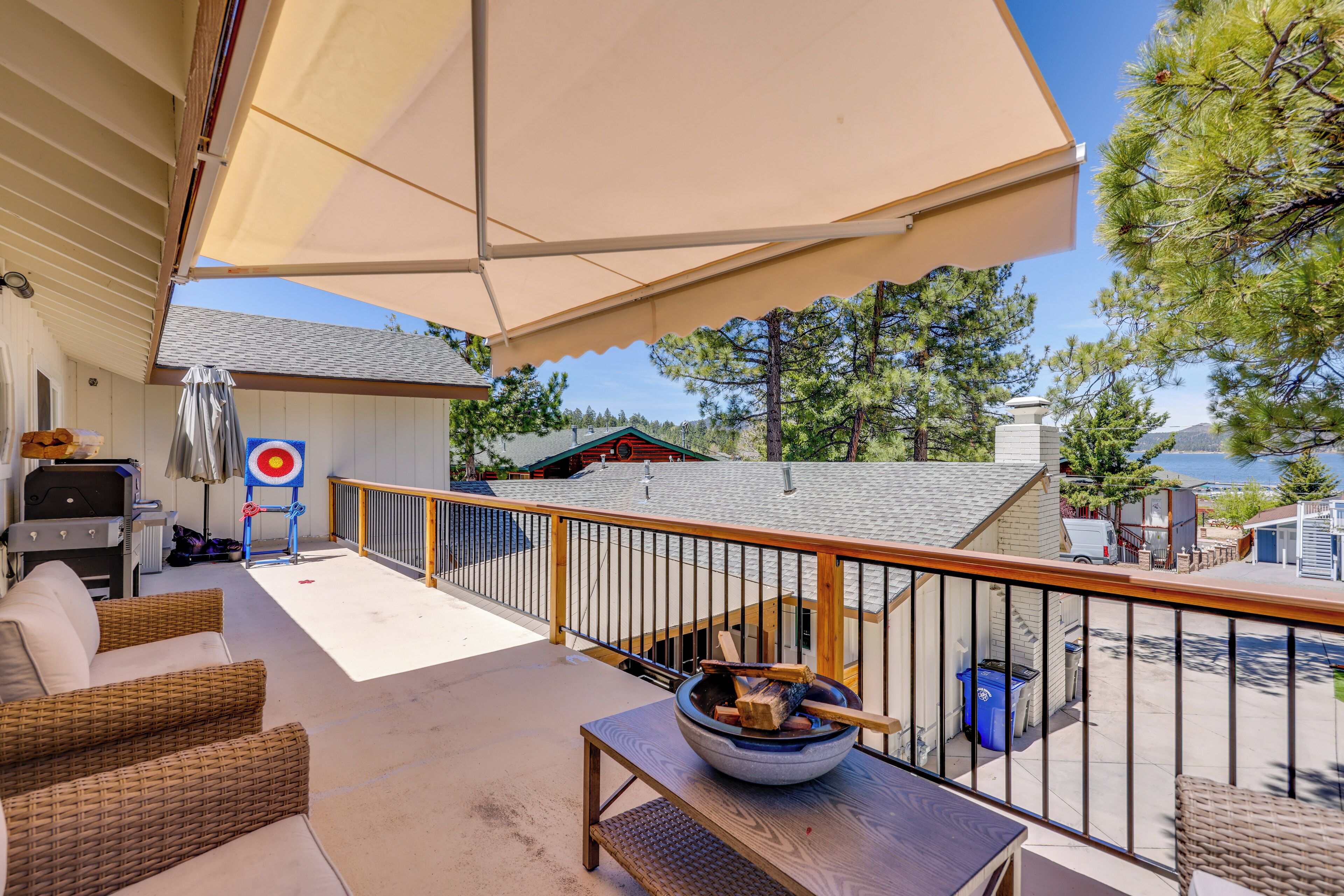 A covered outdoor area with wicker furniture, a table with a bowl, and a target on the wall.