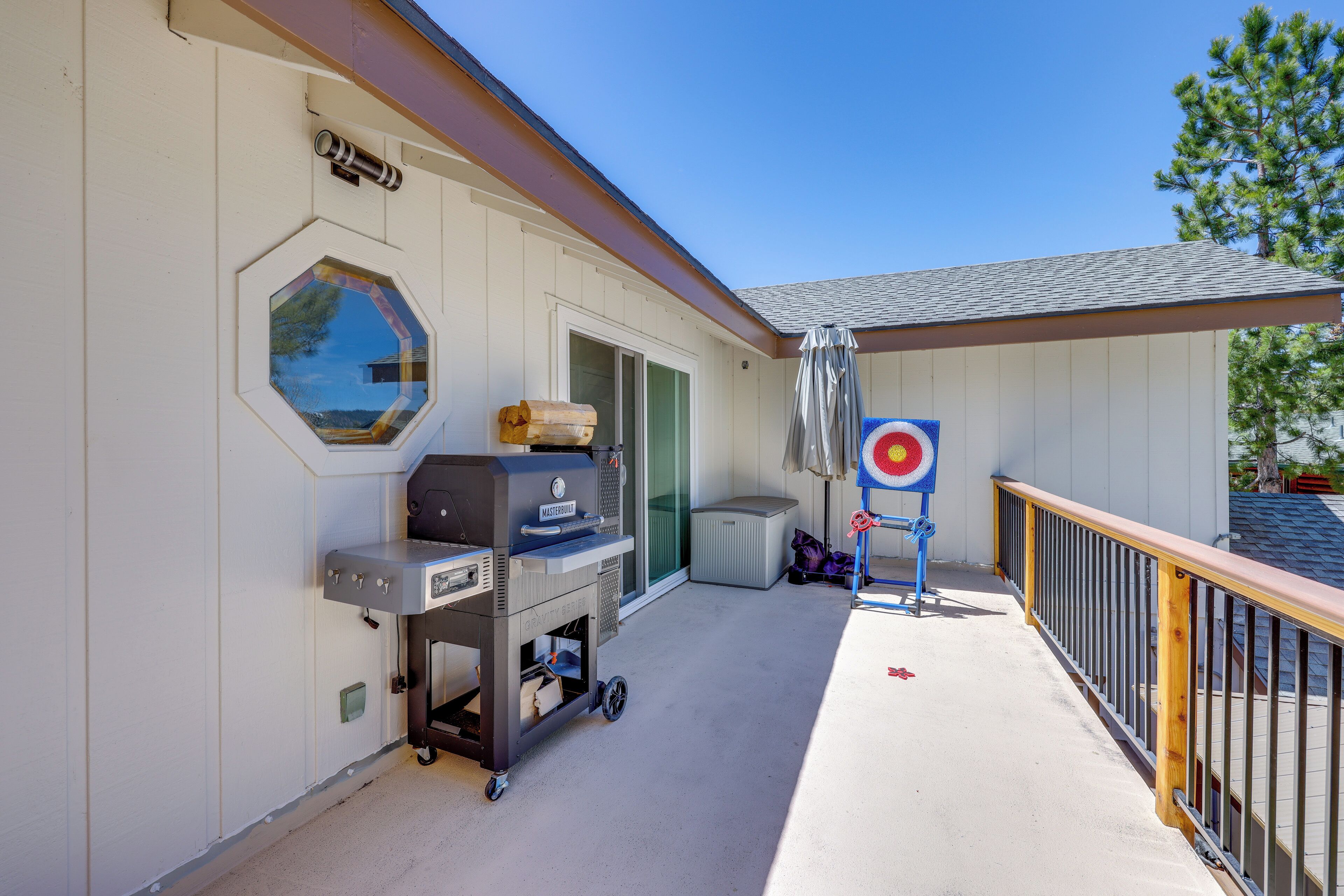 A covered outdoor area with a barbecue grill, a target, and a window.