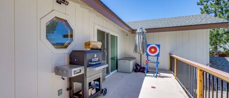 A covered outdoor area with a barbecue grill, a target, and a window.