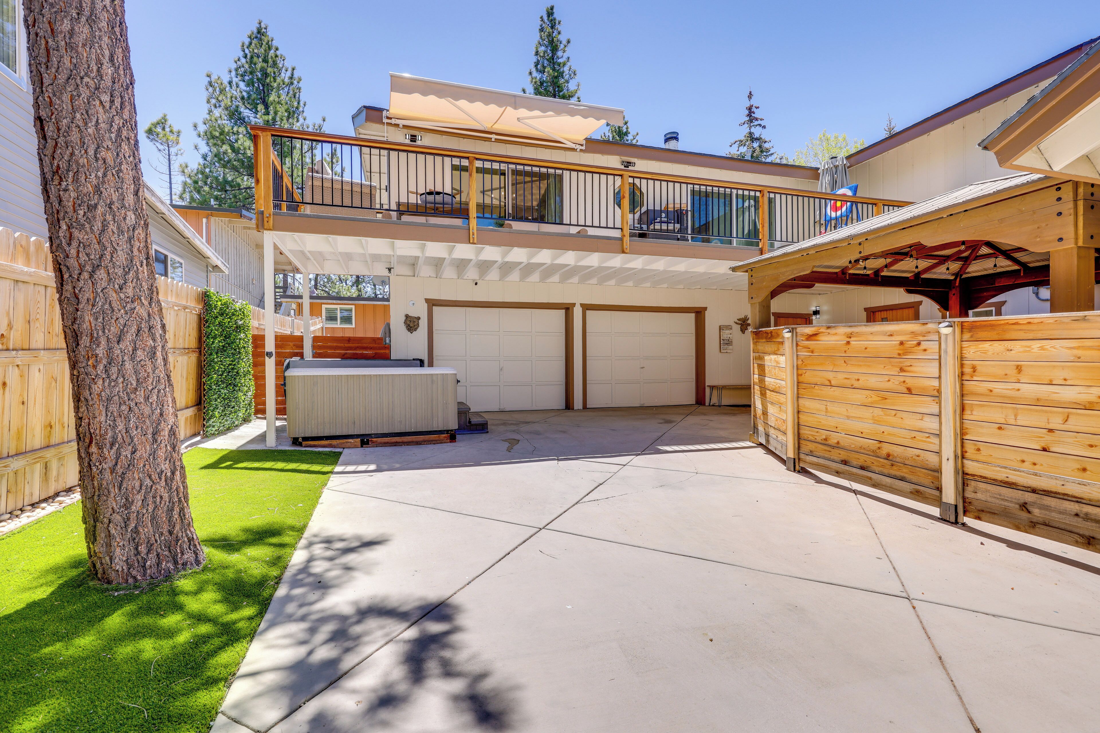 A two-story house with a covered patio, a fenced backyard, and a garage.