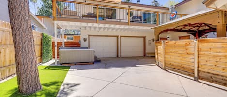 A two-story house with a covered patio, a fenced backyard, and a garage.