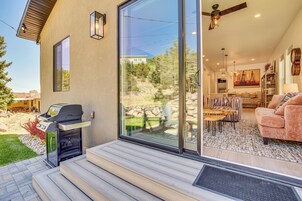 Una casa moderna con un patio, una parrilla y un salón con sofá y un cuadro.