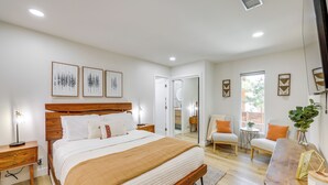 Una camera da letto con un letto grande, comodini, una sedia e un tavolino con una pianta.