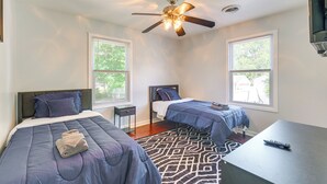 Ein Schlafzimmer mit zwei Betten, einem Deckenventilator und einem Fenster.