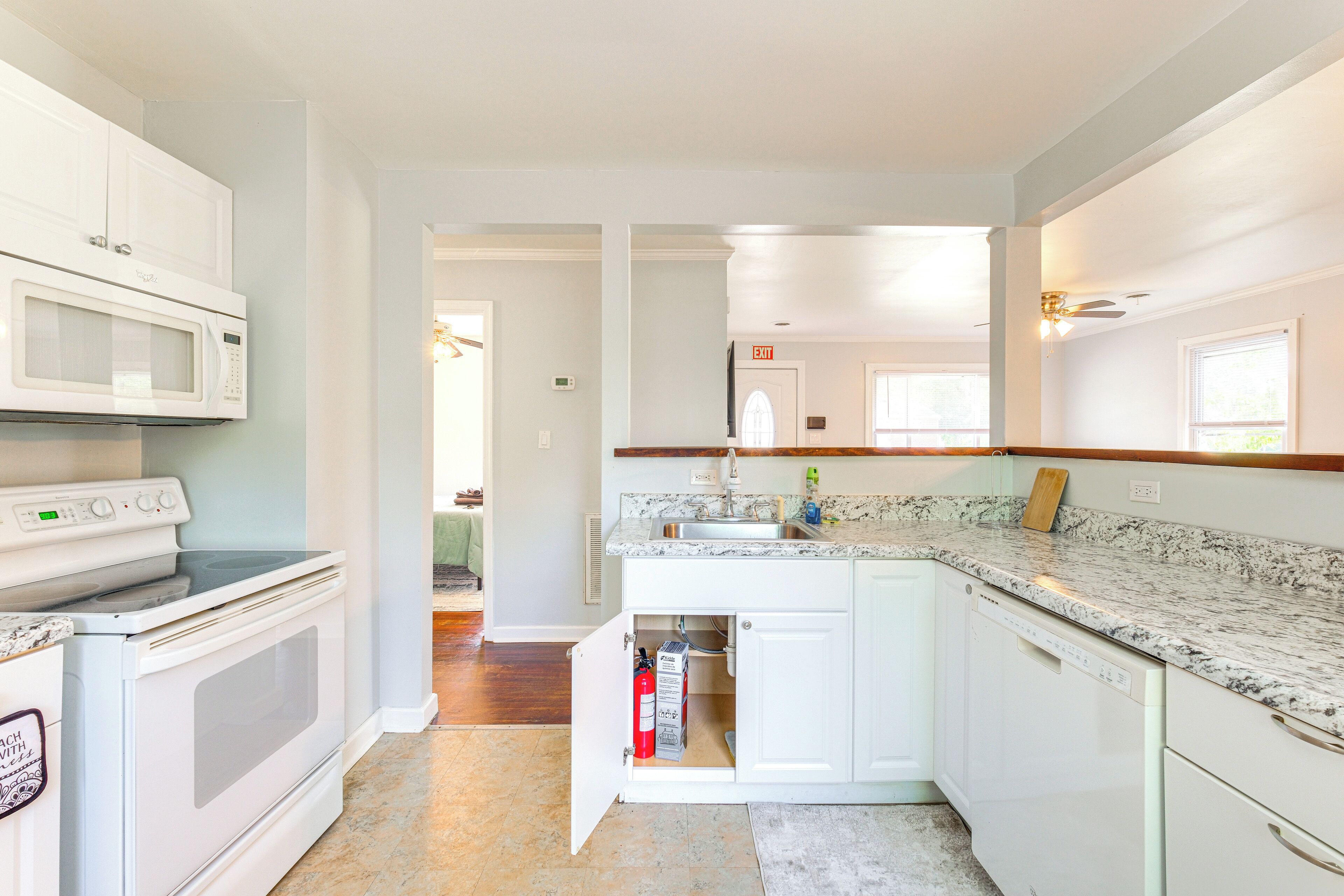 A modern kitchen with white cabinetry, a built-in microwave, a stove, and a dishwasher.