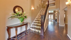 A grand staircase with a dark wooden finish and a tiled design, leading to an upper floor. - Large Luxury Home With Saltwater Pool (Denton)