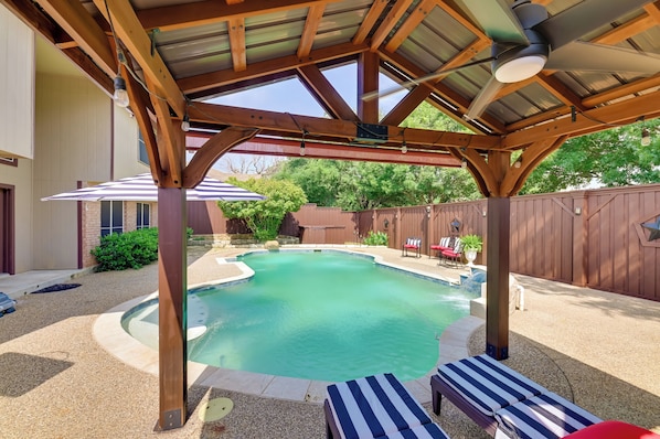 Relax by the pool in a serene, setting with a covered patio and lounge chairs.