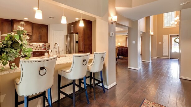 A spacious kitchen with a central island, bar stools, and pendant lighting. - Large Luxury Home With Saltwater Pool (Denton)