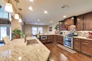 Enjoy cooking in this well-equipped kitchen with a large island, double oven, and ample counter space.