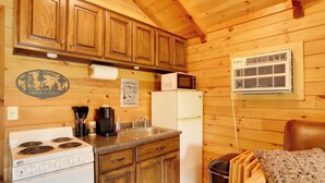 A wooden cabin kitchen with a stove, sink, refrigerator, and microwave. - 1 Mi to Current River: Cozy Studio Cabin! (Van Buren)