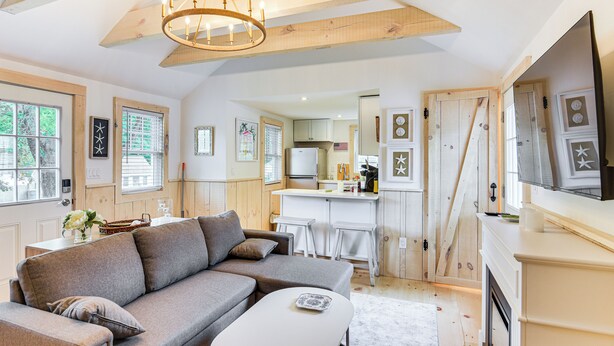 Ein modernes Wohnzimmer mit einem Ecksofa, einem Couchtisch und einem Kamin.