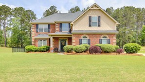 A two-story brick house with a front porch, a garage, and a well-maintained lawn. - 9 Mi to Trilith Studios: Gem in Fayetteville! (Fayetteville)