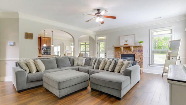 A spacious living room with a sectional sofa, a fireplace, and a view of the kitchen. - 9 Mi to Trilith Studios: Gem in Fayetteville! (Fayetteville)