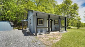 A small, single-story cabin with a porch, surrounded by a well-maintained lawn and trees. - Hike to Fire Tower! Monterey Cabin on 4 Acres (Monterey)