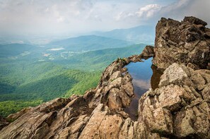 A natural rock formation with a narrow gap creating a reflective water surface.