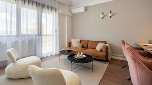 A modern living room with a sofa, two armchairs, a coffee table, and a dining area. - Spacious 3BR by Cismigiu Gardens Calea Victoriei (Bucharest)