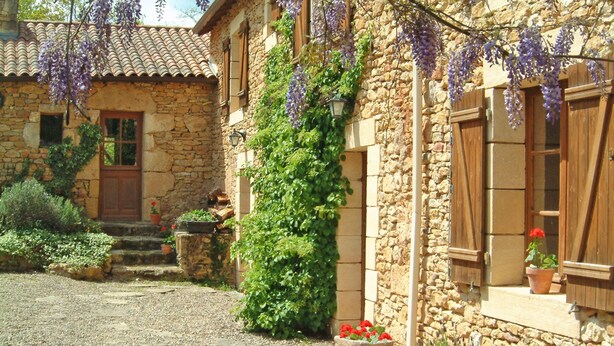 A stone building with a tiled roof, wooden shutters, and potted plants. - La Grange - sleeps 6 guests  in 3 bedrooms (Larzac)