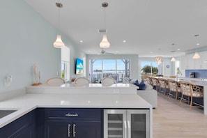 A modern kitchen with a central island, dark cabinetry, and pendant lighting.