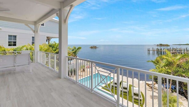 Ein Balkon mit Meerblick, ein Pool und eine Anlegestelle.