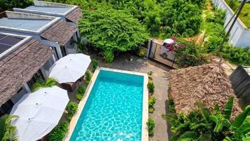 Una piscina en la azotea con vistas a abundante vegetación y un cielo despejado.