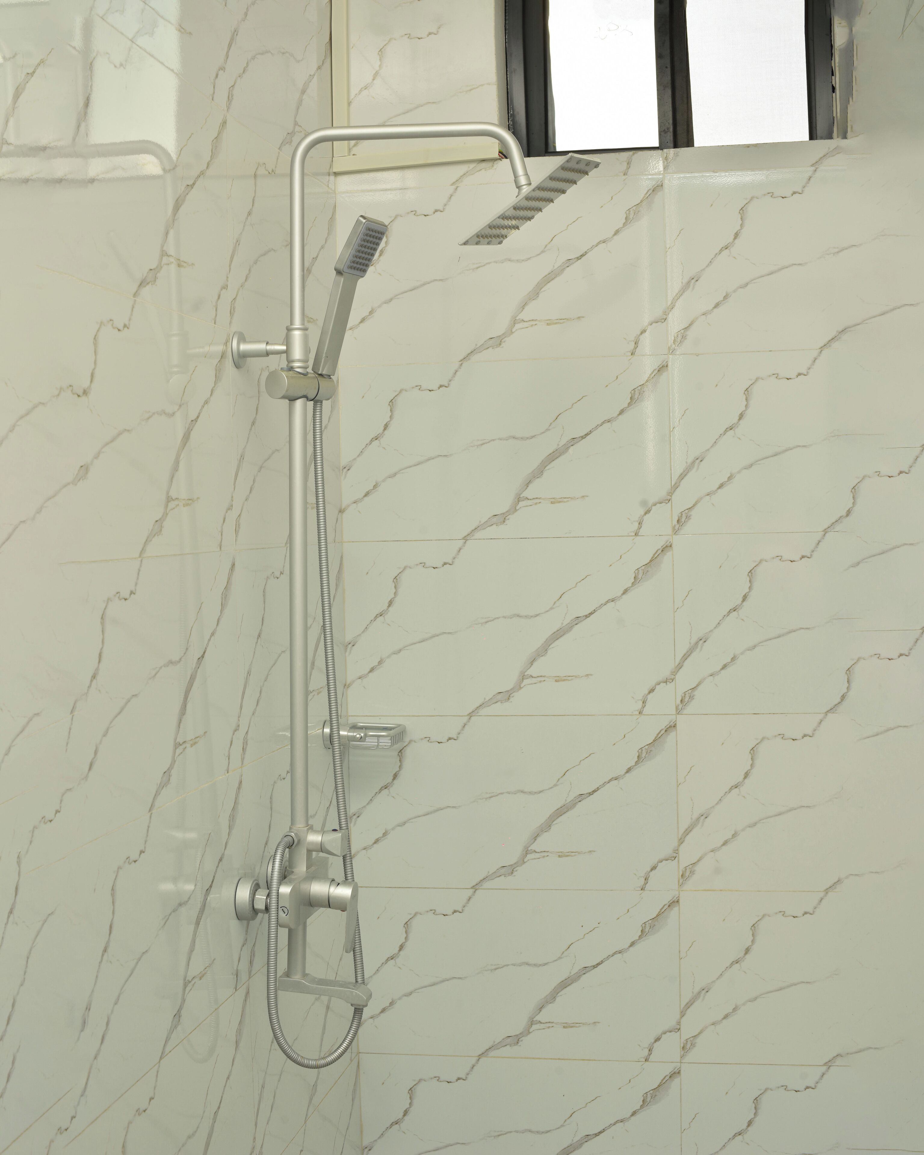 A shower with a handheld showerhead and a handheld shower attachment, mounted on a wall with a marble pattern.