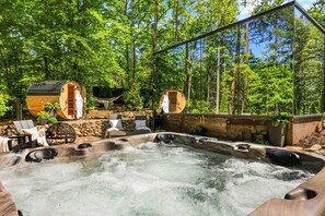 Un jacuzzi rodeado de cabañas de madera en un bosque.