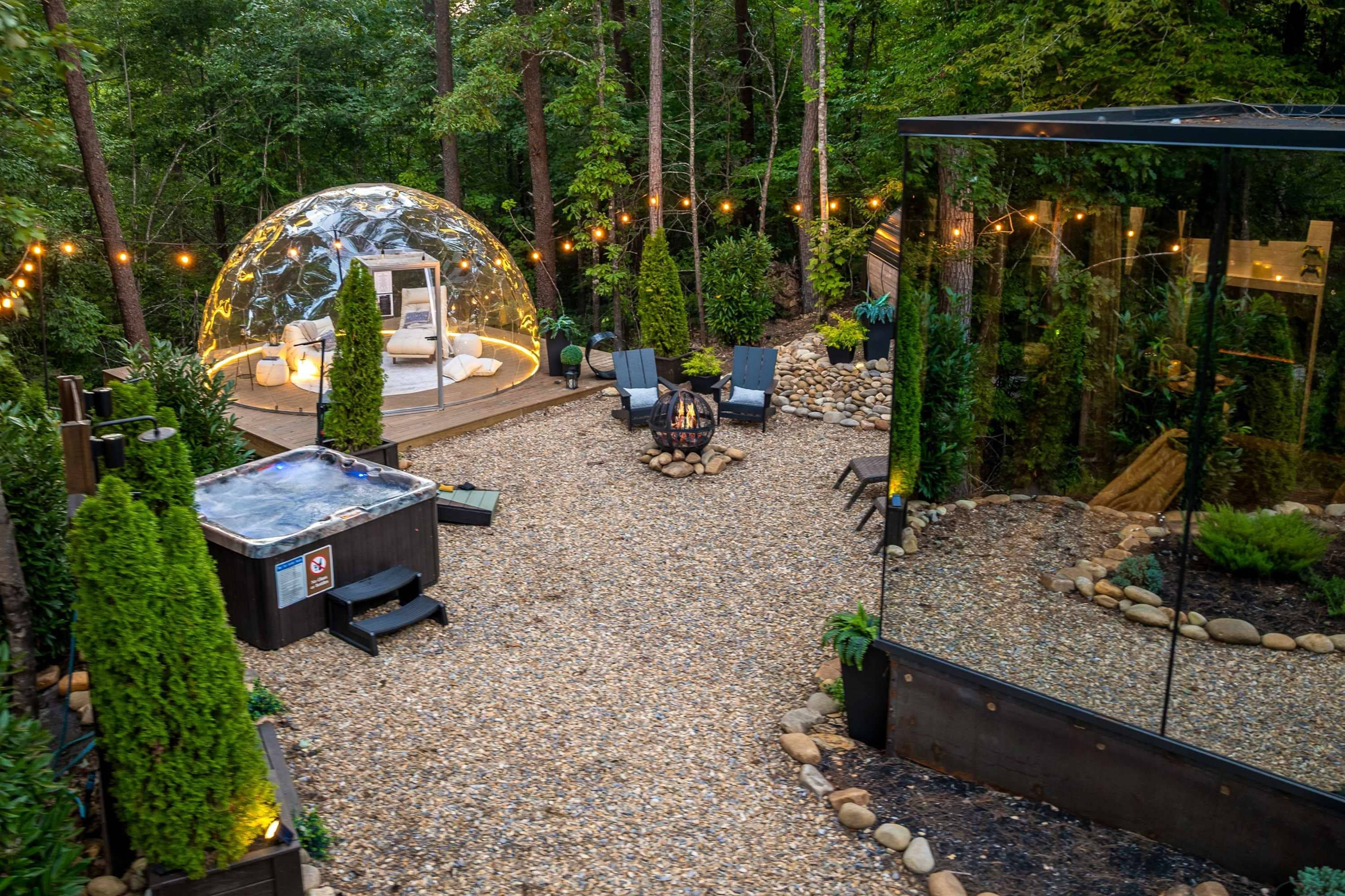 Un espacio exterior acogedor con jacuzzi, asientos y una estructura con cúpula de vidrio.