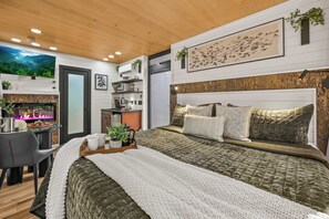 Un dormitorio moderno con una cama grande, un escritorio y un televisor.