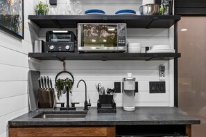 A modern kitchen with a built-in microwave, toaster, and coffee maker. - Villa Sol-Mirror Cabin-Private-Hot Tub-FirePit-Luxury (Sevierville)