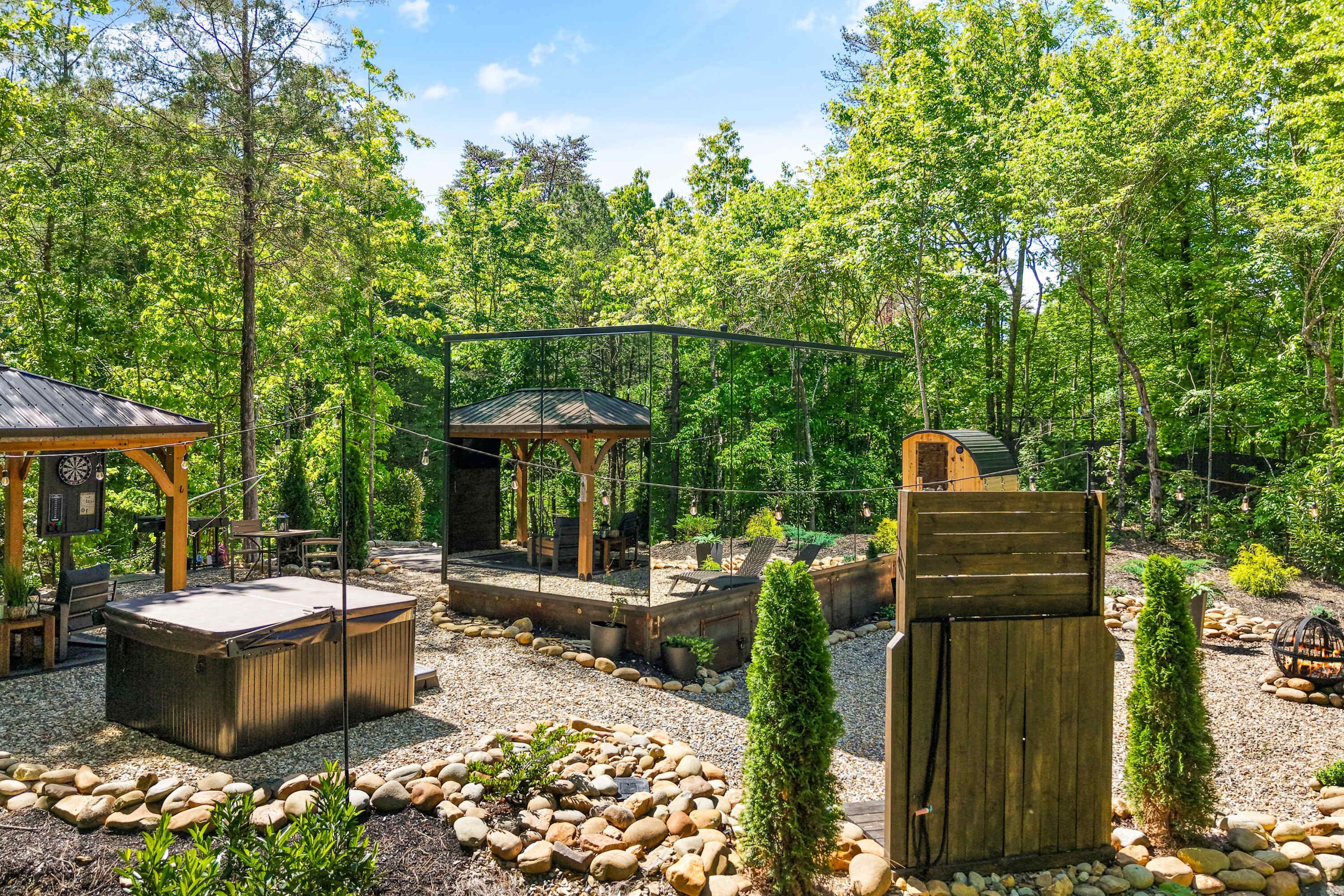 Un espace extérieur rustique agrémenté de structures en bois, de sièges et d’un chemin en pierre.
