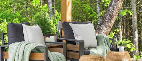 An outdoor seating area with two chairs, a table, and a woven basket.