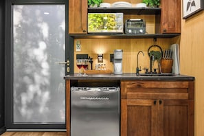 Una cocina compacta equipada con lavavajillas, cafetera, tostadora y pileta.