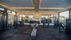 A gym with various exercise equipment, large windows, and a ceiling with recessed lighting. - Rewaya Majestic Resort (Hurghada)