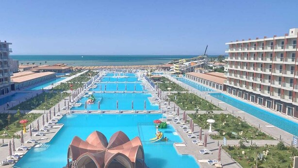 A resort with multiple swimming pools, a central water slide, and a beach view. - Rewaya Majestic Resort (Hurghada)