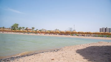 Aan een privéstrand, ligstoelen, parasols, strandlakens